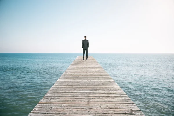 Man permanent op de pier en op zoek naar de afstand van de oc — Stockfoto