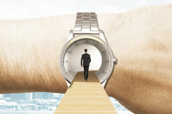 Time travel concept with businessman walking into the watches on