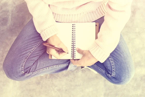 Hipster-Mädchen mit Tagebuch und Stift auf Betonboden — Stockfoto