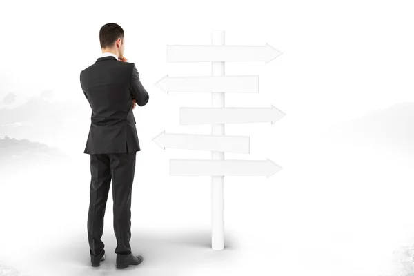 Man stands and thinks about blank signpost directions — Stock Photo, Image