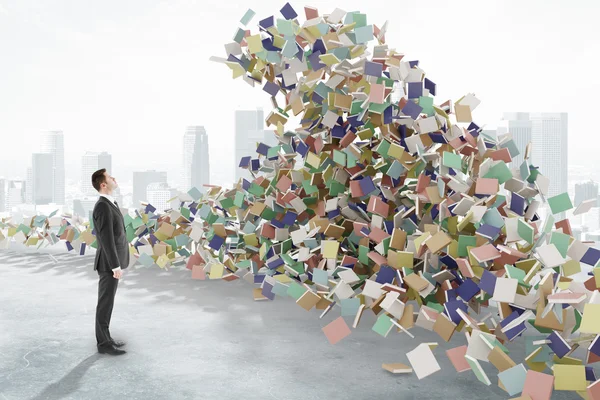 L'homme regarde les vagues de tsunami composées de livres, d'éducation co — Photo