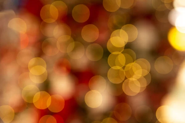 Bokeh in dark colors. Dark Christmas bokeh. Red with orange bokeh from the garland. Dark blurred background. Orange blurred background.