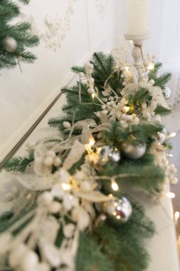 Odanın yeni yıl dekoru. Şömine çelenk ve oyuncaklarla süslenmiş.