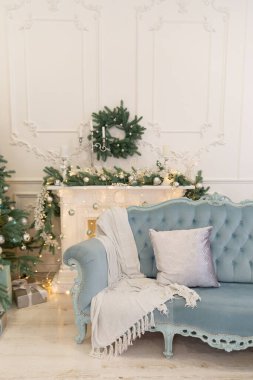 Odanın yeni yıl dekoru. Şömine çelenk ve oyuncaklarla süslenmiş.