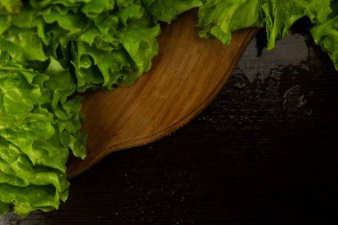 Marul yaprakları tahtada, üst manzarada. Ahşap bir arka planda marul yaprakları.