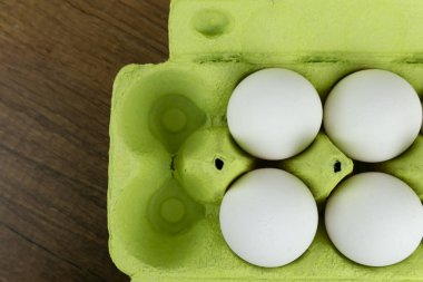 Açık karton bir kutunun içindeki beyaz tavuk yumurtalarının en üst görüntüsü. Taze tavuk yumurtası. Yumurtalar kutuda, yakın plan. Yemek malzemeleri..