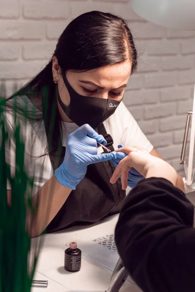 Manicurist Makes Manicure Blue Gloves Client Using Gel Nail Polish — Stock Photo, Image