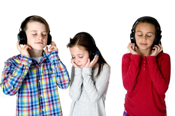 Tres preadolescentes escuchando música con auriculares ojos cerrados pe —  Fotos de Stock