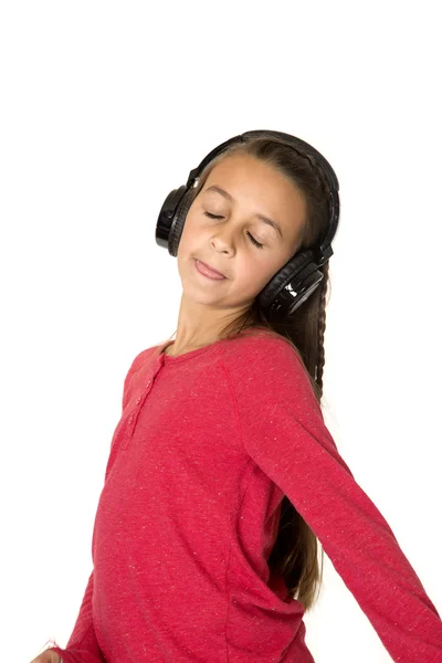 Preadolescente chica con los ojos cerrados lengua fuera escuchando música cabeza — Foto de Stock