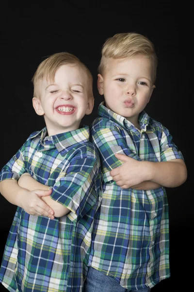 Retrato de dois meninos bonitos de pé braços dobrados expressões engraçadas — Fotografia de Stock