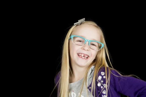 Menina loira jovem usando óculos de aro azul sorrindo dentes ausentes — Fotografia de Stock