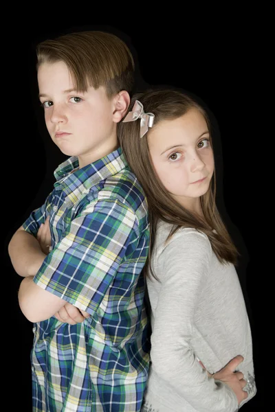 Portriat of boy with arms folded and girl with hands on her hips — Stock Photo, Image