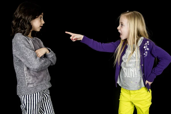 Blondes Mädchen zeigt anklagend mit dem Finger auf süße Freundin großer Ausdruck — Stockfoto