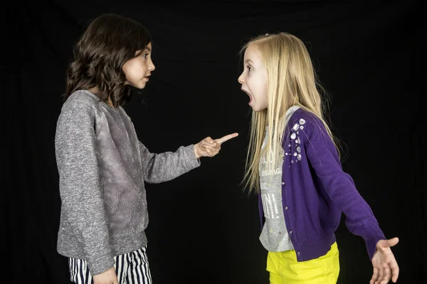 Duas meninas bonitos discutindo uma menina apontando o dedo para o dente — Fotografia de Stock