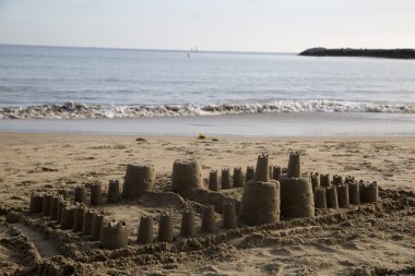 Büyük çocuk kum kale beach küçük okyanus dalgaları üzerinde