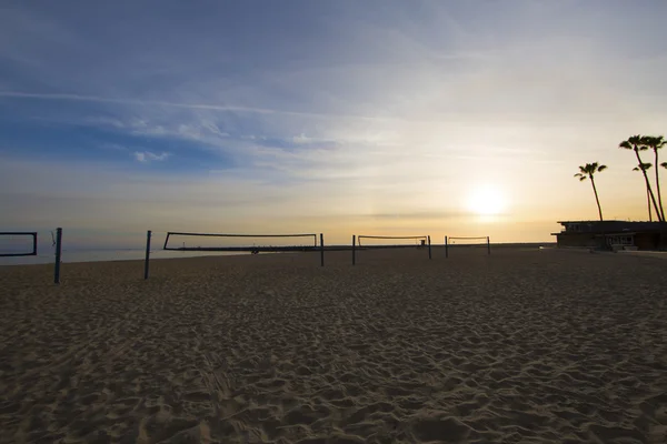 Atardecer pacífico en la playa redes de voleibol de arena palmeras — Foto de Stock