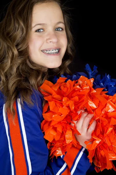 Portrait of teen cheerleader holding pom poms smiling with brace — Stock Photo, Image