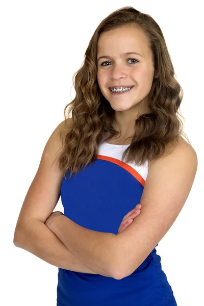 Cute teenage cheerleader wearing blue uniform with arms folded s — Stock Photo, Image