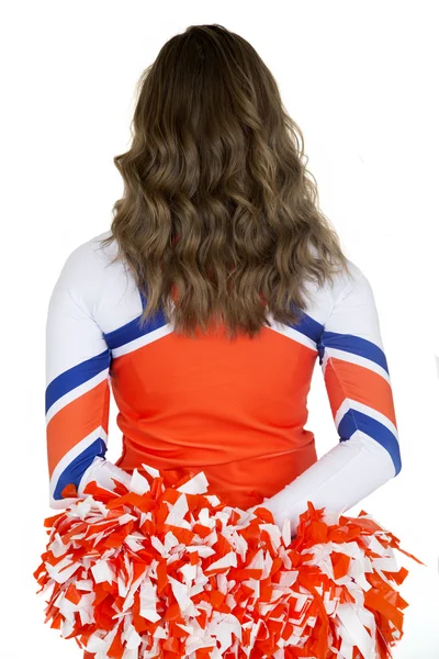 Back of a girl cheerleader holding orange and white pom-poms — Stock Photo, Image