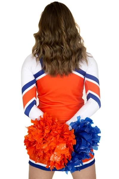 Bakifrån av en tonåring cheerleader holding blått och orange pom-poms Stockbild