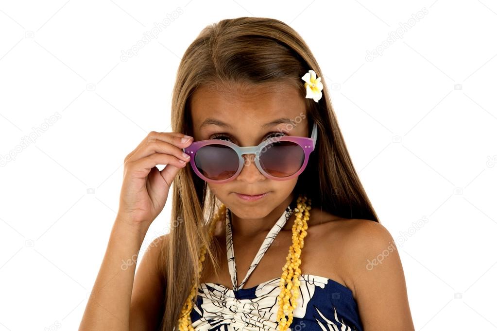 adorable girl in island style dress peering over her sun glasses