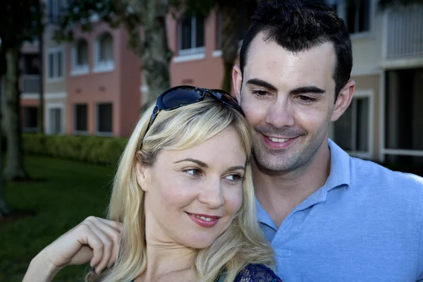 Happy young couple cuddling looking away from camera — Stock Photo, Image