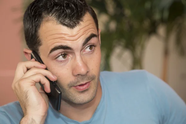 Młody mężczyzna ciemnych włosach męski model mówić na jego telefon komórkowy — Zdjęcie stockowe