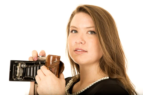 Young woman holding an antique camera with a serious expression — Stock Photo, Image