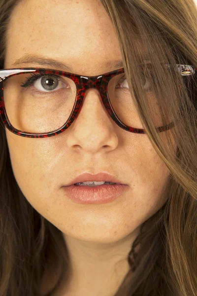 Mujer seria mirando a través de su cabello usando gafas —  Fotos de Stock