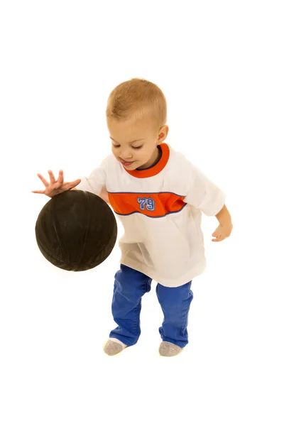 Cute two year old boy bouncing black basketball — Stock Photo, Image