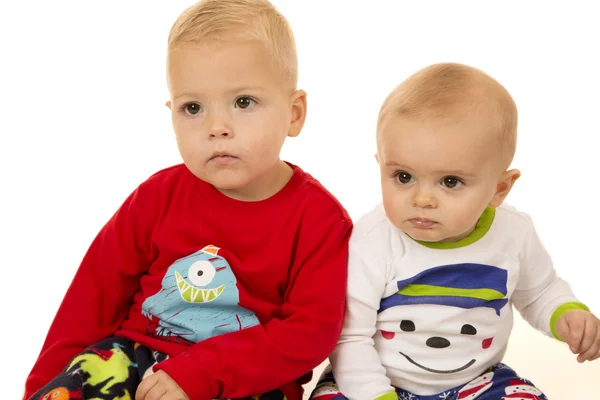 Two young boys wearing winter Christmas pajamas staring — Stock Photo, Image