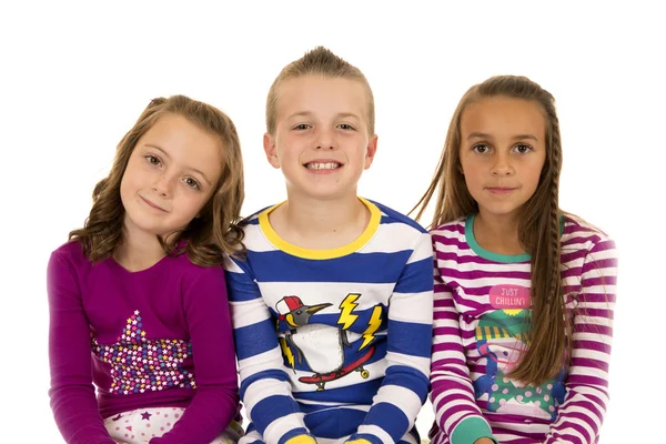 Portrait of three children wearing colorful winter pajamas — Stock Photo, Image