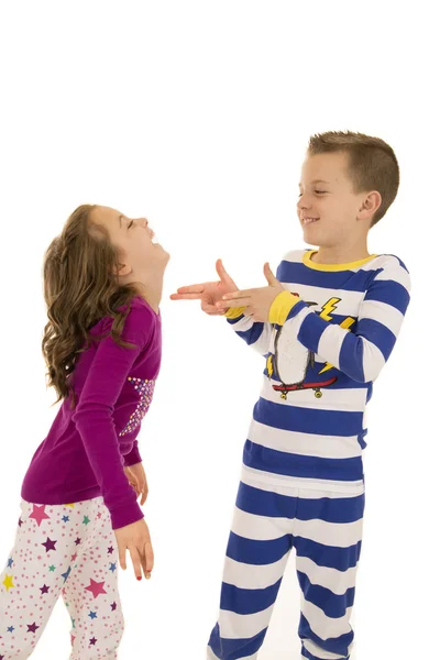 Chlapec a dívka, která nosí zimní pyžamo hrát šťastné — Stock fotografie
