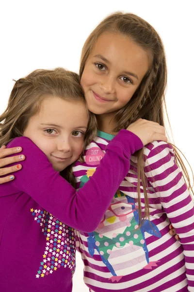 Two cousin girls wearing christmas pajamas hugging each other — Stock Photo, Image