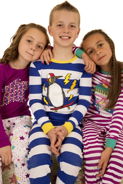 Tři děti nosí pyžamo zimní sezení usmíval se šťastný Stock Snímky