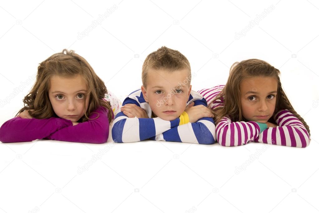 Children laying down wearing pajamas looking at camera