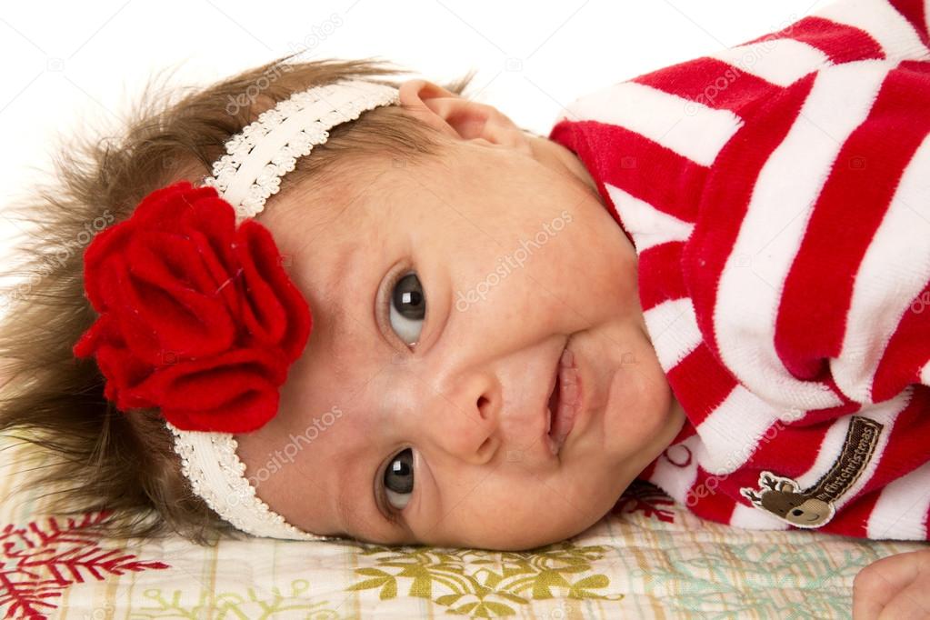 cute newborn girl laying down with flower headband