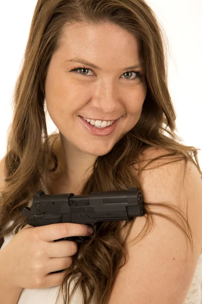 Frau mit schwarzer Pistole hinterhältig lächelnd — Stockfoto