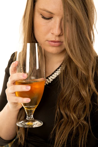 Елегантна молода жіноча модель тримає напій, дивлячись вниз — стокове фото