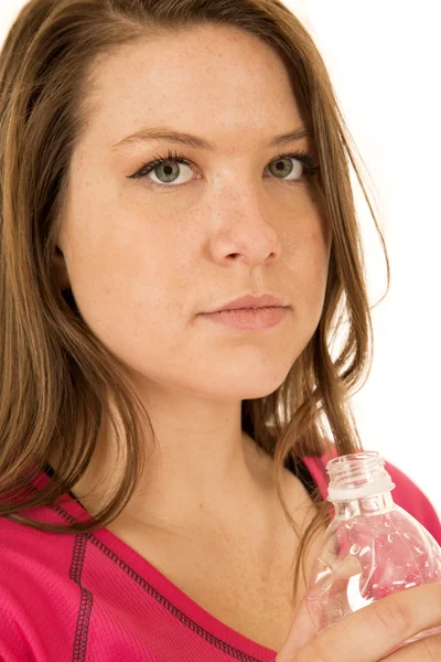 Modello femminile contenente una bottiglia d'acqua con un'espressione seria — Foto Stock