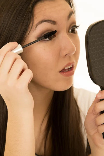 Bellissimo modello adolescente che applica il mascara tenendo lo specchio della mano — Foto Stock