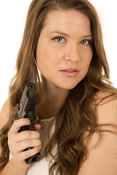 Mulher com uma expressão séria apontando uma pistola preta — Fotografia de Stock