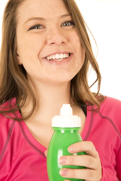 Jovencita sosteniendo una botella de agua verde feliz sonriendo — Foto de Stock