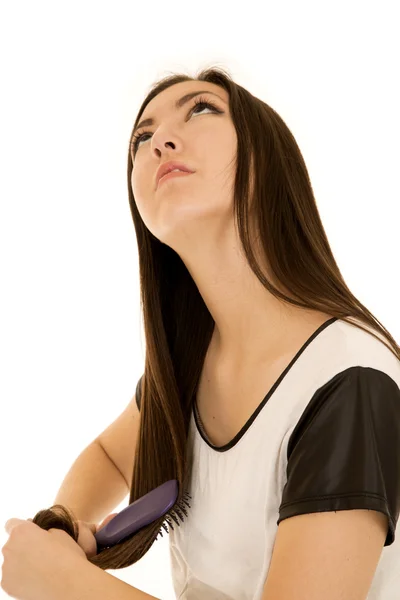 Attractive Asian teen brushing her hair looking up — Stock Photo, Image