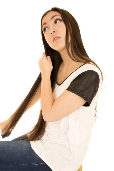Американская азиатка расчесывает свои длинные темные волосы — стоковое фото