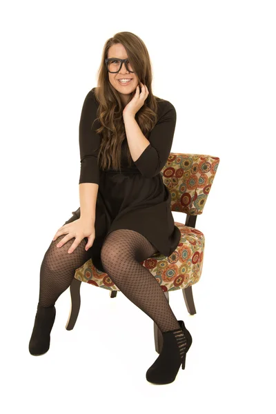 Younger female model sitting in a floral chair — Stock Photo, Image