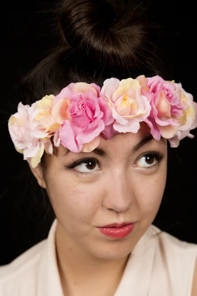 Beautiful young woman wearing a floral crown looking up — Stock Photo, Image