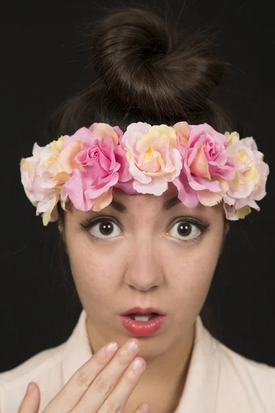 Юная красавица в цветочной короне с удивленным выражением лица — стоковое фото