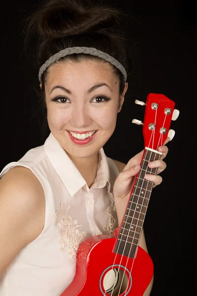 Beautiful teen girl holding a red ukulele smiling — Stock Photo, Image