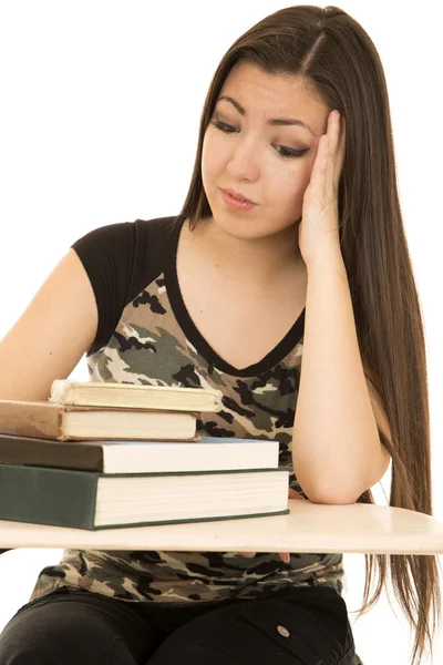 Studentin sitzt am Schreibtisch und grübelt über Bücherstapel — Stockfoto